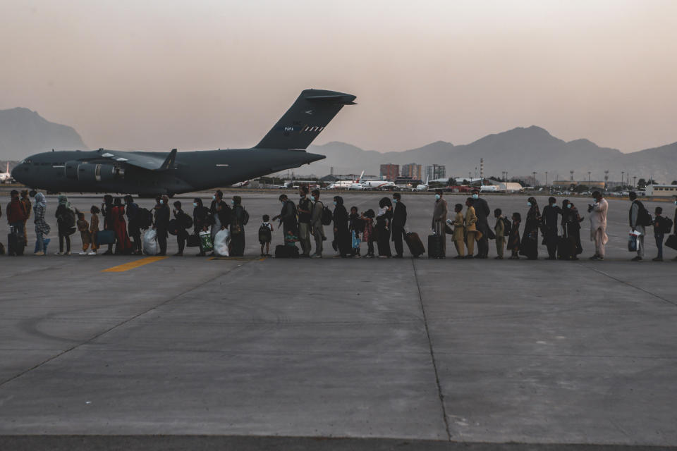 In this image provided by the U.S. Marine Corps, evacuees wait to board a Boeing C-17 Globemaster III, at Hamid Karzai International Airport, Kabul, Afghanistan, Monday, Aug. 23, 2021. (Sgt. Isaiah Campbell/U.S. Marine Corps via AP)