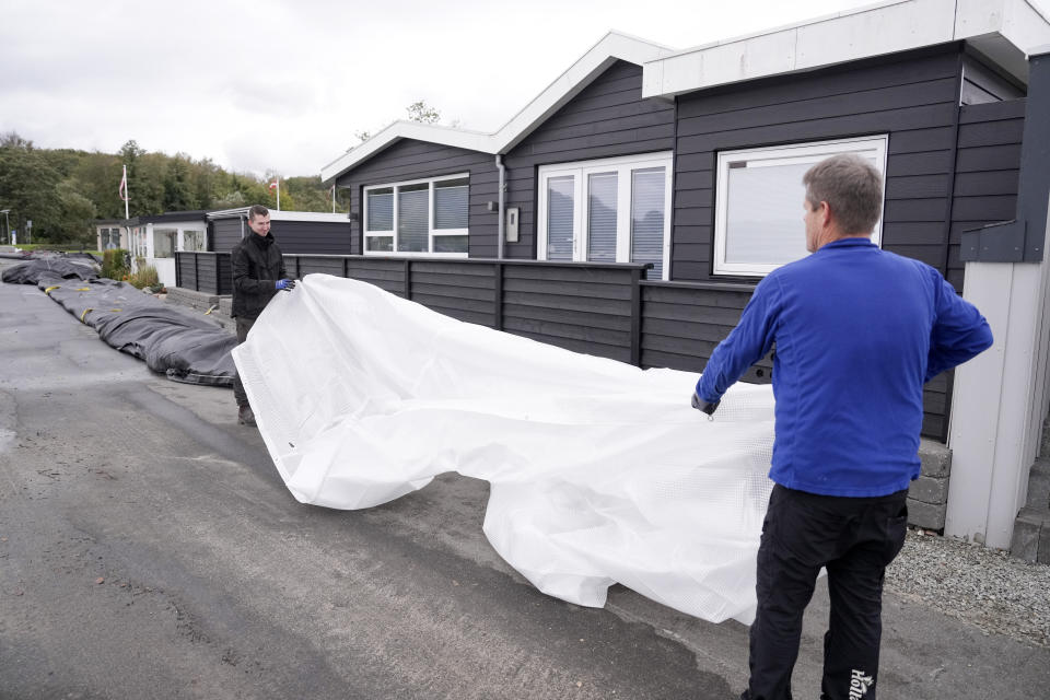 Jacob Nissen and Christian Mikkelsen, right, secure their summer house at Sonderballe Strand near Haderslev southern, Denmark Thursday, Oct. 19, 2023. Southern Scandinavia and northern Germany braced for bad weather with gale force winds over the next days. Authorities said Thursday that floods could cause major problems in inner Danish waters and in the Baltic Sea. (Claus Fisker/Ritzau Scanpix via AP)