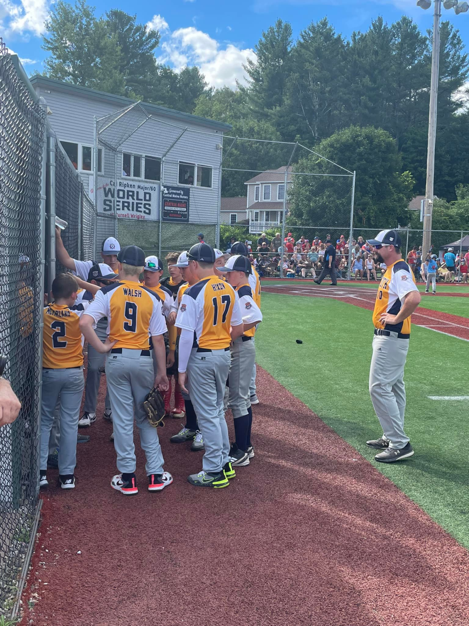 Coach Shaun Walsh huddles up with his Weymouth team in front of the dugout during the Cal Ripken 12U World Series in Waterville, Maine.