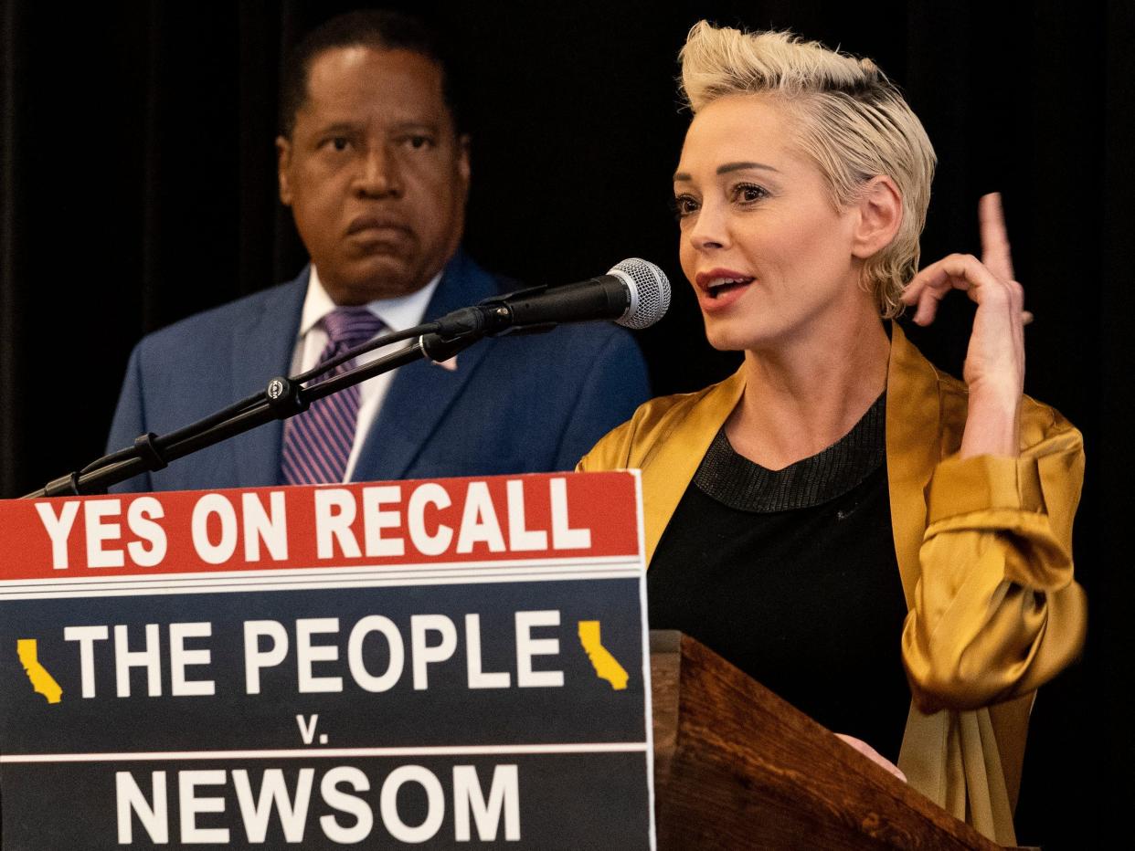 Republican conservative radio talk show host Larry Elder, left, listens as former actress and activist Rose McGowan speaks during as the pair hold a news conference at the Luxe Hotel Sunset Boulevard in Los Angeles Sunday, Sept. 12, 2021.