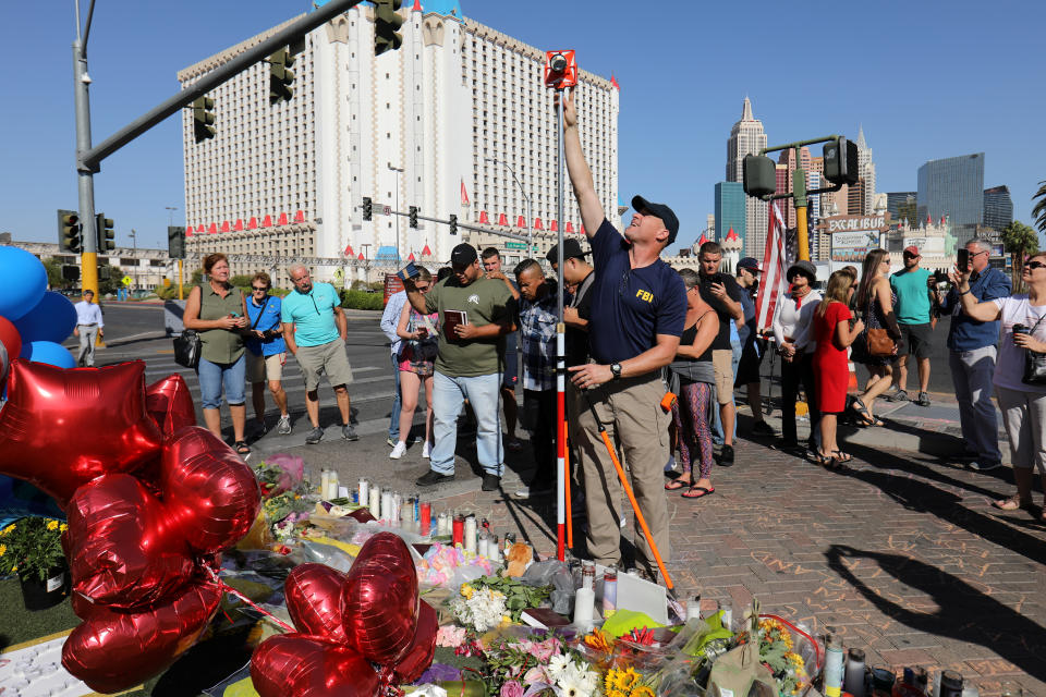 <p>A member of the FBI Evidence Response Team works to map the crime scene near a memorial in the middle of Las Vegas Boulevard following the mass shooting in Las Vegas, Nev., Oct. 4, 2017. (Photo: Mike Blake/Reuters) </p>