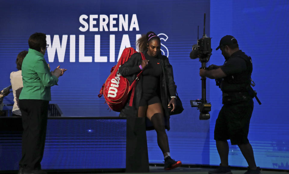 Serena Williams, center, walks onto the court to face Maria Sharapova in their first-round match at the U.S. Open tennis tournament in New York, Monday, Aug. 26, 2019. Tennis great Billie Jean King, left, looks on. (AP Photo/Charles Krupa)