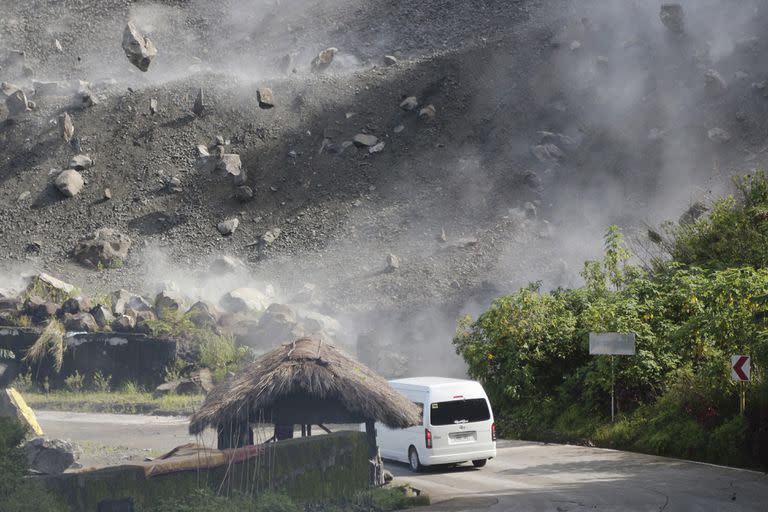 Rocas caen mientras un vehículo sortea una carretera durante un terremoto en Bauko, Provincia de la Montaña, Filipinas, el miércoles 27 de julio de 2022.