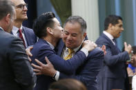 Assemblyman Phil Ting, D-San Francisco, right, chairman of the Assembly Budget Committee is congratulated by fellow Bay Area Democrat, Assemblyman Evan Low, left, after the Assembly approved the state budget in Sacramento, Calif., Thursday, June 13, 2019. Both houses of the Legislature approved the $214.8 billion state budget that spends more on health care and education, bolsters the state's top firefighting agency and boost state reserves. (AP Photo/Rich Pedroncelli)