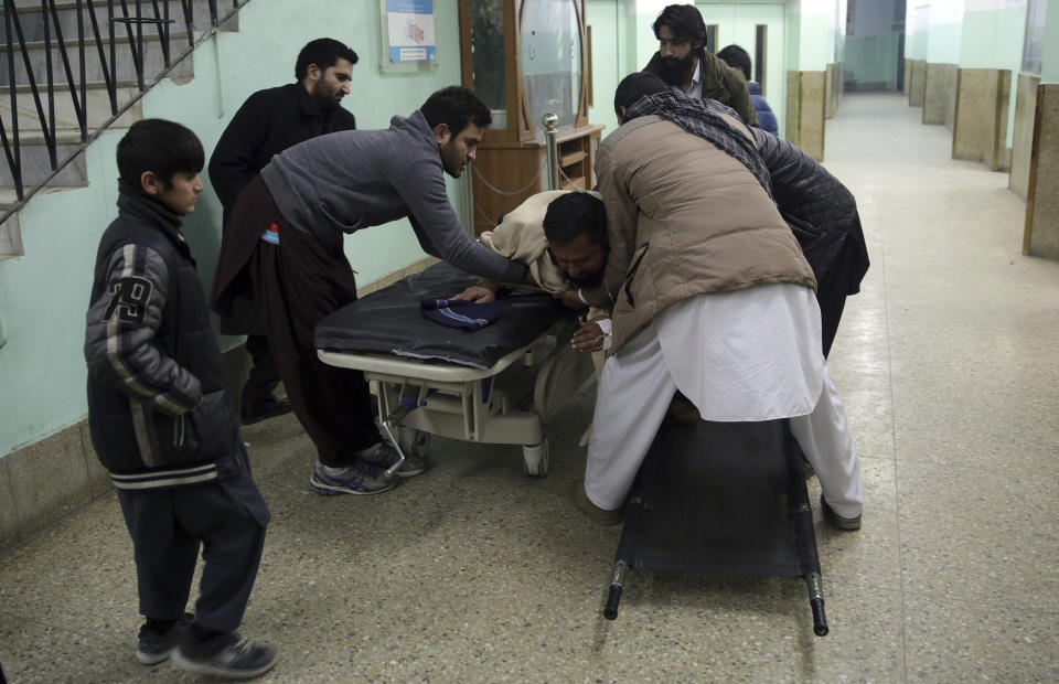 Men assist a wounded relative in a hospital in Kabul, Afghanistan, Monday, Jan. 14, 2019. Afghan officials say multiple people were killed when a suicide bomber detonated a vehicle full of explosive in the capital Kabul on Monday. (AP Photo/Massoud Hossaini)