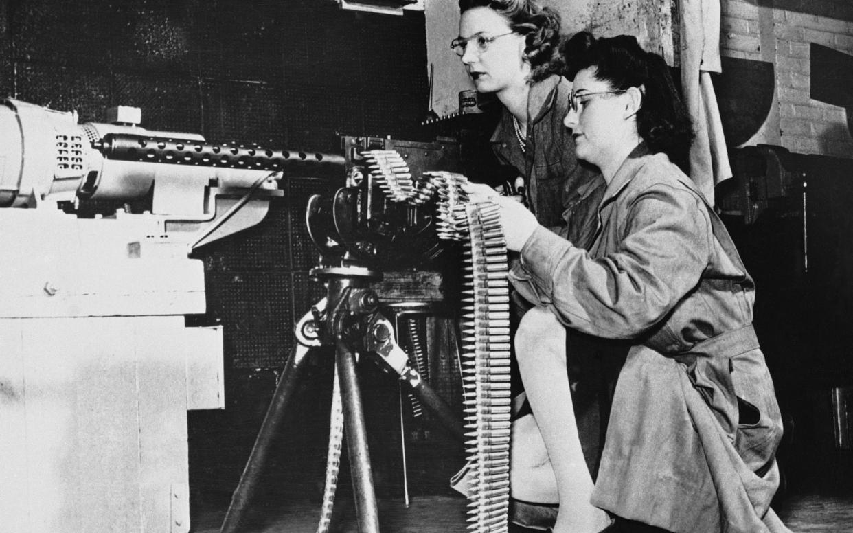 Mae Zelisnky shoots as Betty O'Beda feeds a 30-caliber rifle during an ammunition test at Remington Arms Company - ap