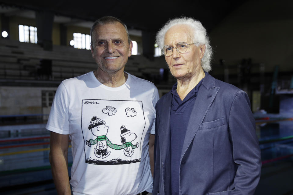 Designer Jean-Charles de Castelbajac, left, and Luciano Benetton, co founder of the Benetton group, pose for photographers at the conclusion of the Benetton Spring-Summer 2020 collection, unveiled during the fashion week, in Milan, Italy, Tuesday, Sept. 17, 2019. (AP Photo/Luca Bruno)