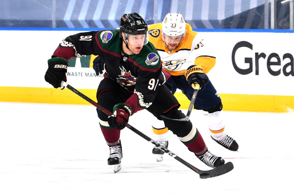 EDMONTON, ALBERTA - AUGUST 05: Taylor Hall #91 of the Arizona Coyotes skates the puck away from Viktor Arvidsson #33 of the Nashville Predators during the first period of Game Three of the Western Conference Qualification Round at Rogers Place on August 05, 2020 in Edmonton, Alberta. (Photo by Andy Devlin/NHLI via Getty Images)