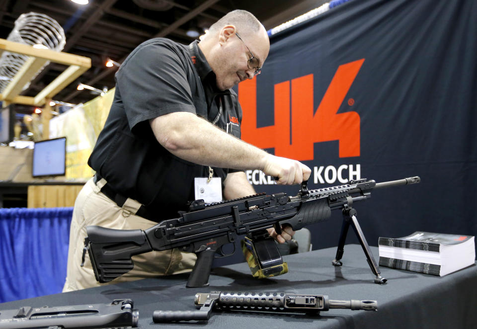 Barry Witt, of Heckler & Koch arms manufacturers, sets up a weapons display at the 8th annual Border Security Expo, Tuesday, March 18, 2014, in Phoenix. The two day event features panel discussions, sharing intelligence, and exhibitors displaying high-tech wares aimed at securing lucrative government contracts and private sales. (AP Photo/Matt York)