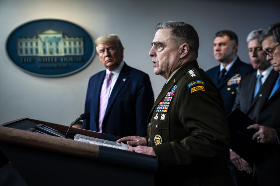 Gen. Mark Milley, chairman of the Joint Chiefs of Staff, speaks at a podium as then-President Donald Trump listens in the background.