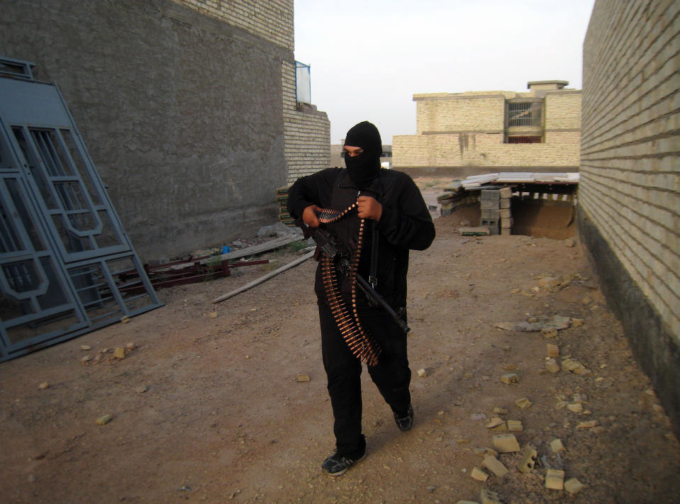 In this Monday, April 28, 2014 photo, a masked anti-government gunman holds his weapon as he patrols in Fallujah, Iraq. Al-Qaida-linked fighters and their allies seized the city of Fallujah and parts of the Anbar provincial capital Ramadi in late December after authorities dismantled a protest camp. Like the camp in the northern Iraqi town of Hawija whose dismantlement in April sparked violent clashes and set off the current upsurge in killing, the Anbar camp was set up by Sunnis angry at what they consider second-class treatment by the Shiite-led government. (AP Photo)