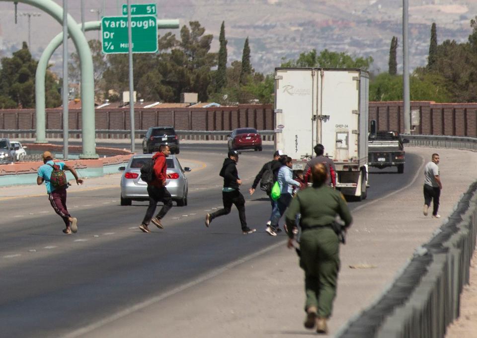 Migrants cross the westbound lanes on the Border Highway in El Paso, Texas after entering the U.S. without proper documentation. Customs and Border Protection officers were able to apprehend the migrants. 