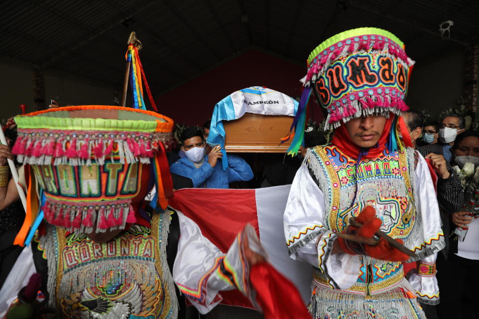 Men in Indigenous clothing walk in front of the coffin of Inti Sotelo Camargo, 24, a student who died during Nov. 14 protests against lawmakers' removal of President Martin Vizcarra, during his funeral procession to a cemetery in Lima, Peru, Monday, Nov. 16, 2020. Peru's political turmoil took a turn Sunday when interim leader Manuel Merino quit and Congress couldn't decide on his replacement, leaving the nation without a president and in crisis less than a week after legislators removed Vizcarra. (AP Photo/Rodrigo Abd)