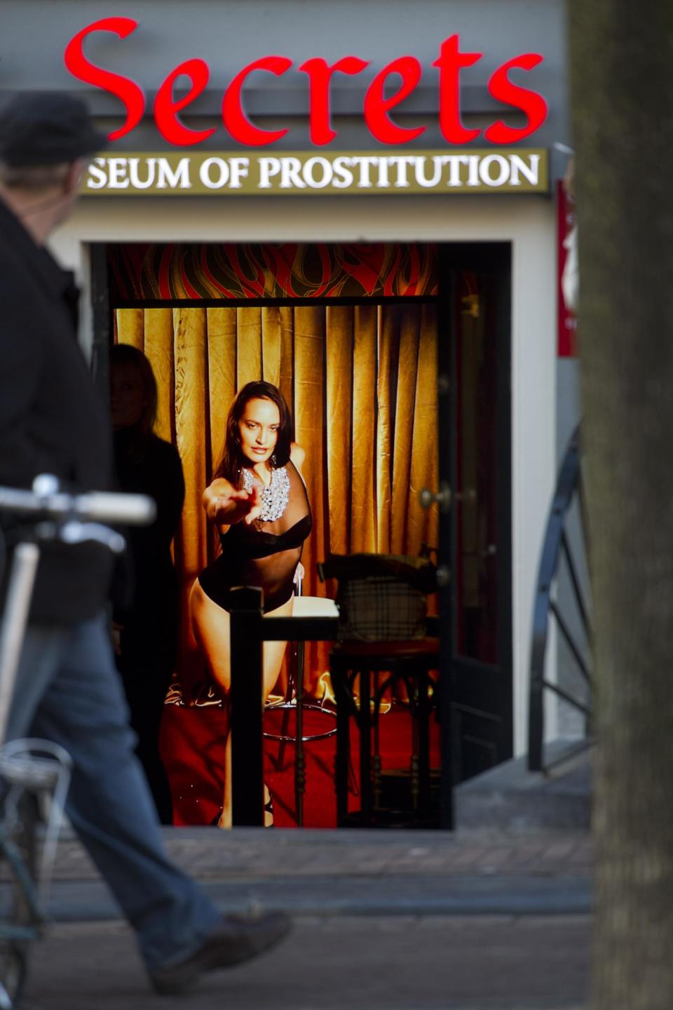 In this photo taken Tuesday, Feb. 4, 2014 a hologram of a beckoning prostitute is shown at the entrance of the 'Red Light Secrets' museum in Amsterdam. On any given evening, thousands of tourists stroll down the narrow streets of Amsterdam's famed Red Light District, gawking at ladies in lingerie who work behind windows, making a living selling sex for money. Now a small educational museum is opening in heart of the district that aims to show reality from the other side of the glass. Organizer Melcher de Wind says the Red Light Secrets museum is for those who want to learn more about how the area works without actually visiting a prostitute. (AP Photo/Evert Elzinga)