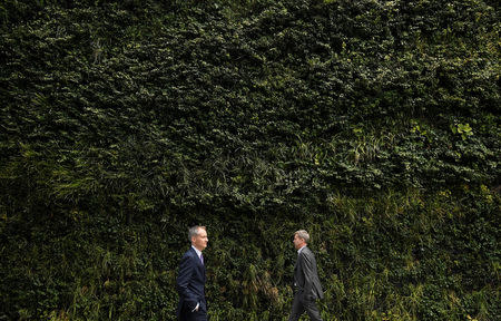 Workers walk past a foliage covered wall of an office building in the City of London financial district, London, Britain, January 25, 2018. Picture taken January 25, 2018. REUTERS/Toby Melville