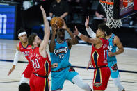 Memphis Grizzlies' Jaren Jackson Jr. (13) shoots between New Orleans Pelicans' Nicolo Melli (20) and Jaxson Hayes (10) during the first half of an NBA basketball game Monday, Aug. 3, 2020 in Lake Buena Vista, Fla. (AP Photo/Ashley Landis, Pool)