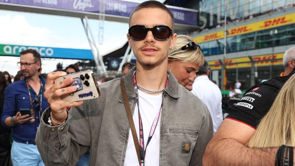 romeo beckham wearing sunglasses and holding out his cell phone to take pictures and photos