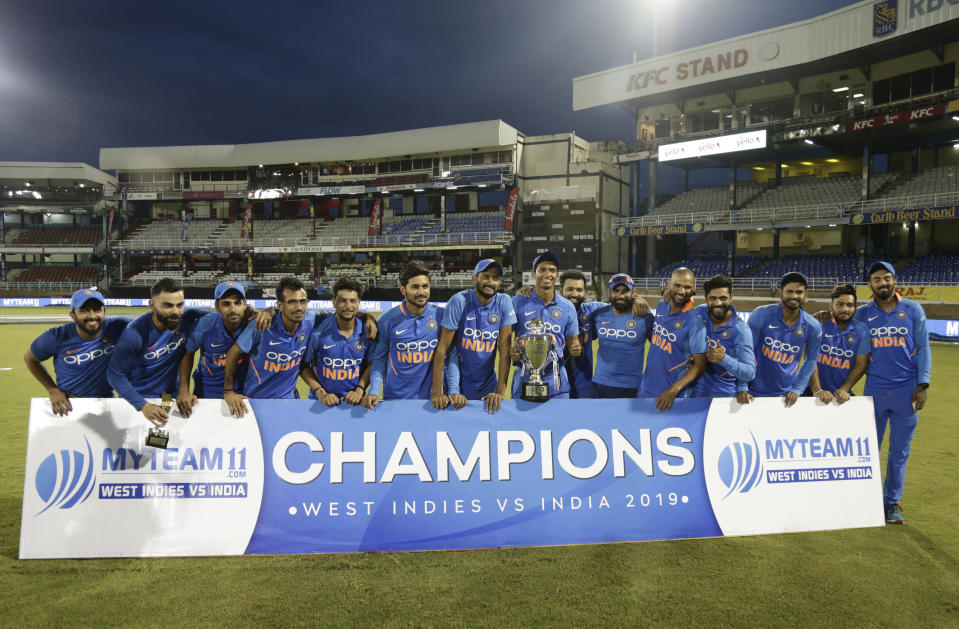 Champion series cricketers from India poses for a photo with the banner and trophy at the end of the third One-Day International cricket match against West Indies in Port of Spain, Trinidad, Wednesday, Aug. 14, 2019. India won by 6 wickets, with 15 balls remaining. (AP Photo/Arnulfo Franco)