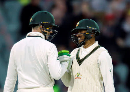 Australian batsman Peter Handscomb (L) reacts with team mate Usman Khawaja h in Adelaide. REUTERS/Jason Reed/File photo