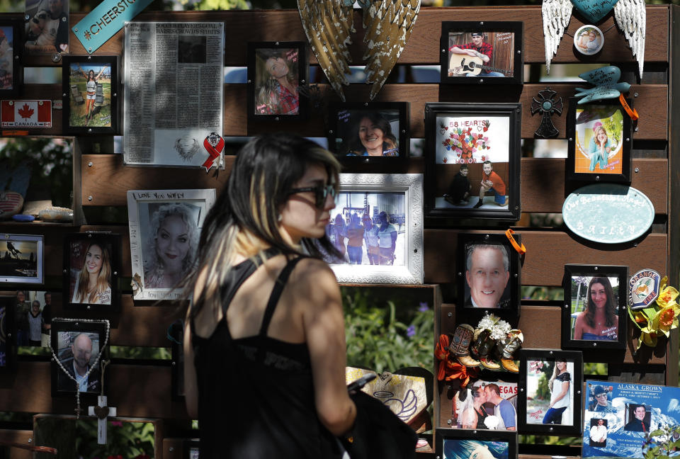 People visit a memorial garden for victims of a mass shooting in Las Vegas, Thursday, Oct. 3, 2019, in Las Vegas. Two years after a shooter rained gunfire on country music fans from a high-rise Las Vegas hotel, MGM Resorts International reached a settlement that could pay up to $800 million to families of the 58 people who died and hundreds of others who were injured, attorneys said Thursday. (AP Photo/John Locher)