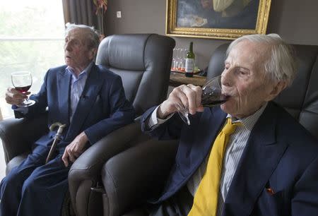 The world's oldest living twin brothers, Paulus (L) and Pieter Langerock from Belgium, 102, drink wine while sitting in their living room at the Ter Venne care home in Sint-Martens-Latem, Belgium, August 11, 2015. REUTERS/Yves Herman