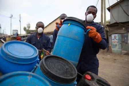 A team of people takes away canisters of human waste from a Sanergy Fresh Life toilet in Mukura Kwa Ruben