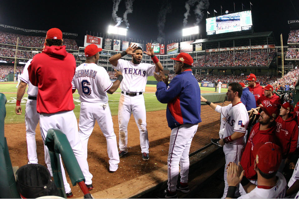 ARLINGTON, TX - OCTOBER 23: Elvis Andrus #1, Esteban German #6 and and manager Ron Washington celebrate after Mike Napoli #25 hits a three-run home run in the sixth inning during Game Four of the MLB World Series against the St. Louis Cardinals at Rangers Ballpark in Arlington on October 23, 2011 in Arlington, Texas. (Photo by Tom Pennington/Getty Images)