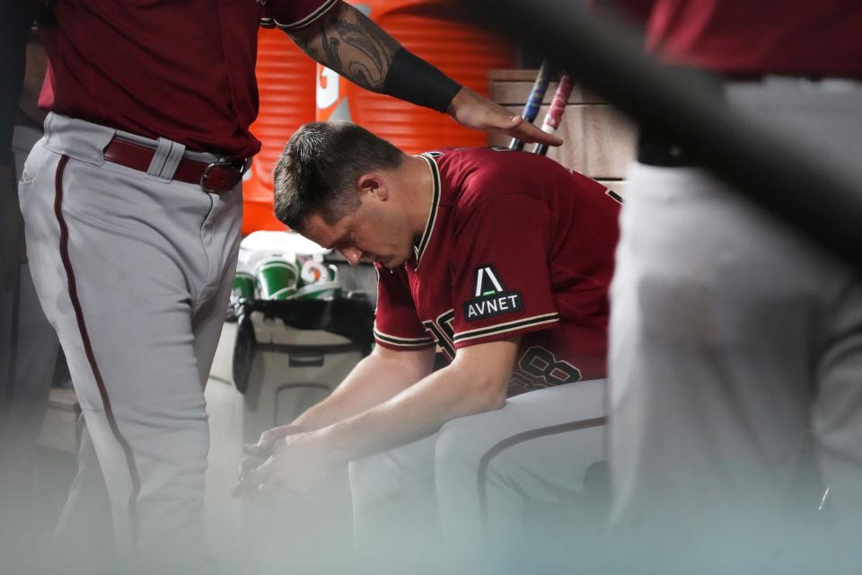 Arizona Diamondbacks pitcher Paul Sewald (38) is comforted by teammates after giving up a 2-run hoe run in the bottom of the ninth to tie the game with the Texas Rangers during Game 1 of the World Series at Globe Life Field in Arlington, Texas, on Oct. 27, 2023.