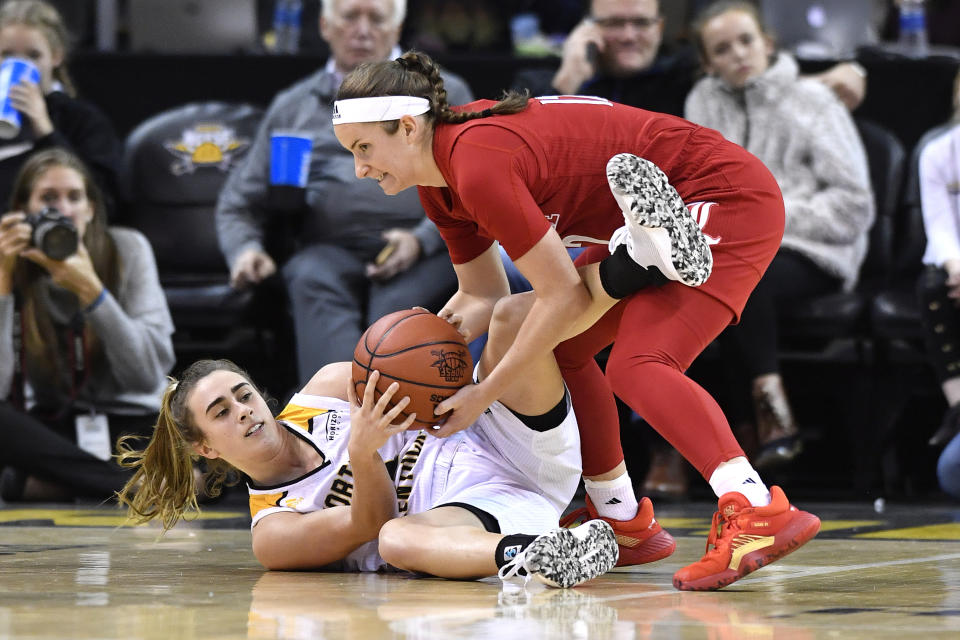 Louisville guard Lindsey Duvall (12), top, battles Northern Kentucky guard Carissa Garcia (12) for a loose ball during the second half of an NCAA college basketball game in Highland Heights, Ky., Sunday, Dec. 8, 2019. Louisville won 85-57. (AP Photo/Timothy D. Easley)