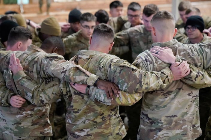 Soldiers assigned to the 82nd Airborne Division gather for prayer before boarding a C-17 transport plane for deployment to Eastern Europe amid escalating tensions between Ukraine and Russia.