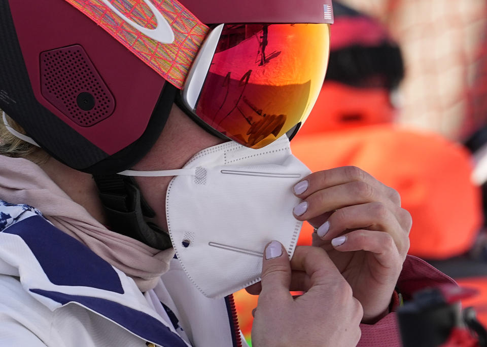 Mikaela Shiffrin of the United States adjusts her face mask before heading to the gondola to go up the alpine ski course for a training run at the 2022 Winter Olympics, Thursday, Feb. 10, 2022, in the Yanqing district of Beijing. Two-time Olympic champion and pre-games medal favorite, Mikaela Shiffrin has skied out in the first run of both the slalom and giant slalom. (AP Photo/Luca Bruno)