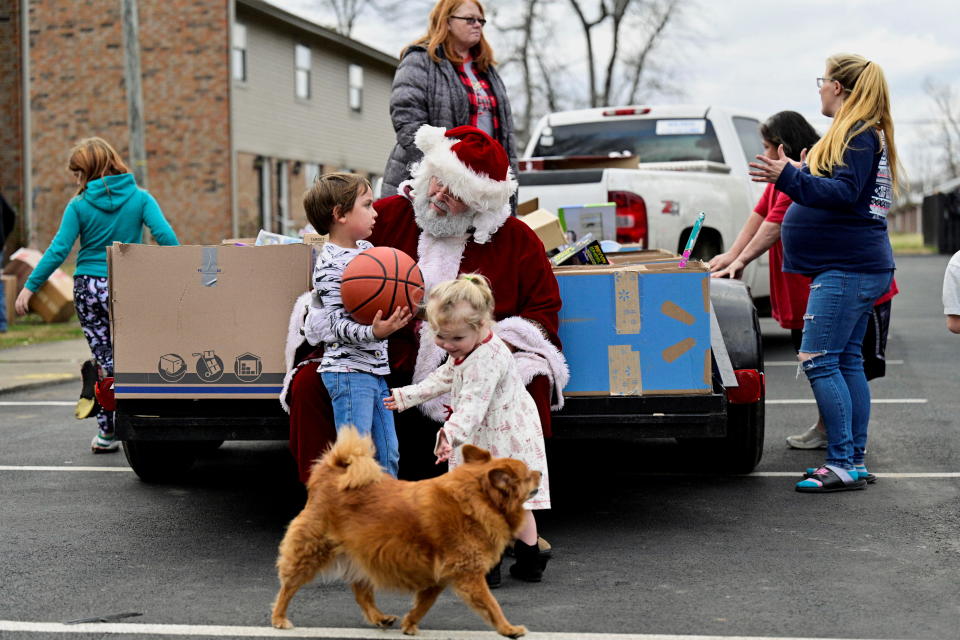 Troy Black, dressed as Santa Claus, interacts with children during a toy drive on Christmas Eve in a heavily damaged neighborhood after tornadoes ripped through several U.S. states, in Dawson Springs, Kentucky, U.S., December 24, 2021. REUTERS/Jon Cherry