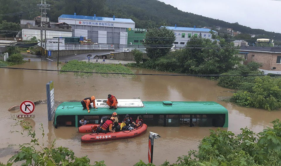Rescue workers evacuate passengers on a boat from a submerged bus due to heavy rain in Paju, South Korea, Thursday, Aug. 6, 2020. Korean Meteorological Administration issued a warning of heavy rain for Seoul and central area. (Paju Fire Station via AP)