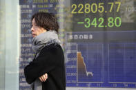 A man walks by an electronic stock board of a securities firm in Tokyo, Thursday, Nov. 21, 2019. Shares skidded Thursday in Asia after moderate declines on Wall Street as anxious mounted over the possibility the U.S. and China may not reach a trade deal before next year. (AP Photo/Koji Sasahara)