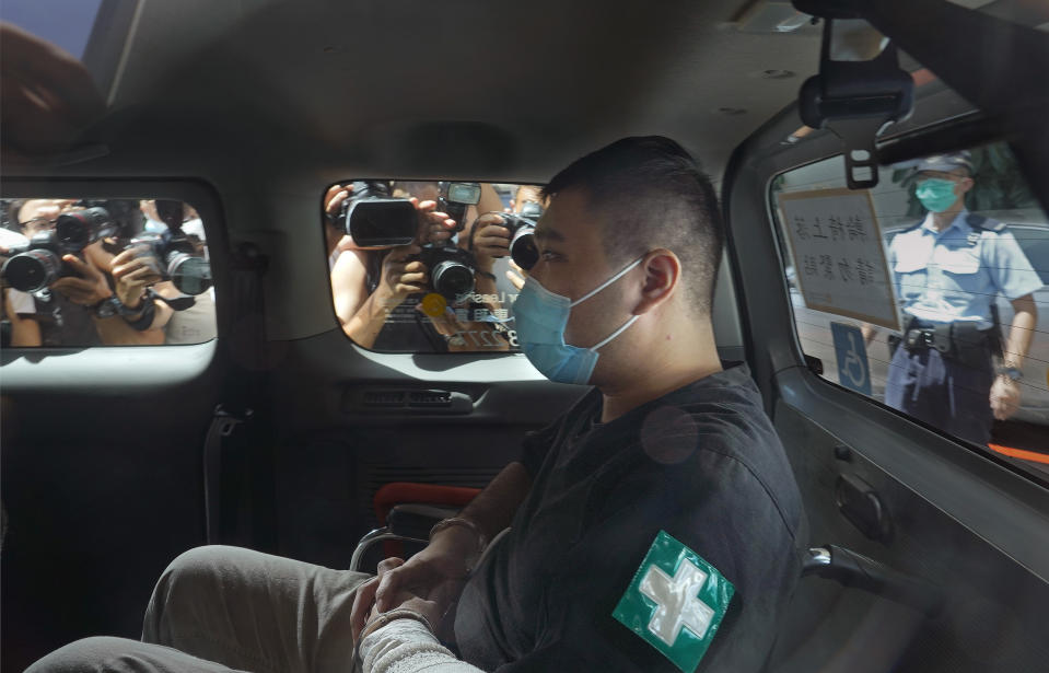 A 23-year-old man, Tong Ying-kit, arrives at a court in a police van in Hong Kong Monday, July 6, 2020. Tong has become the first person in Hong Kong to be charged under the new national security law, for allegedly driving a motorcycle into a group of policemen while bearing a flag with the "Liberate Hong Kong, revolution of our time" slogan. (AP Photo/Vincent Yu)