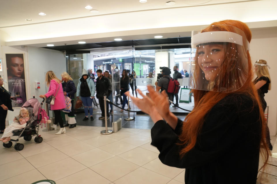 Shop staff in face masks give a round of applause to the first customers through the doors at the Fenwick store in Newcastle.