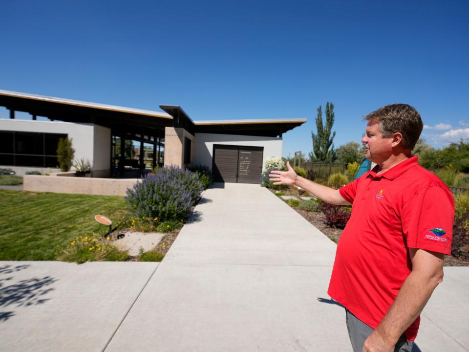 Courtney Brown, the manager for conservation programs for Jordan Valley Water Conservancy District, points out various water conservation measures on display in a front yard model at Conservation Garden Park in West Jordan on Friday, Sept. 15, 2023. | Bethany Baker, The Salt Lake Tribune