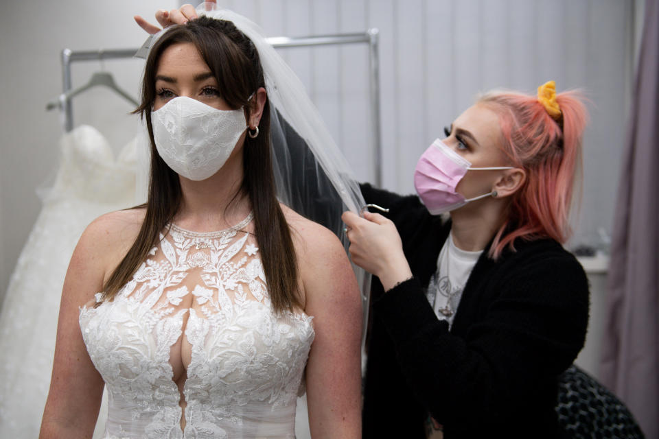 <p>Bride-to-be Erin Barwell tries on dresses for the first time since non-essential retailers reopened this week. Erin, from Stoke-on-Trent, is due to get married next February and tried on dresses at Roberta's Bridal in Burslem, Stoke-on-Trent, following the further easing of lockdown restrictions in England. Picture date: Tuesday April 13, 2021.</p>
