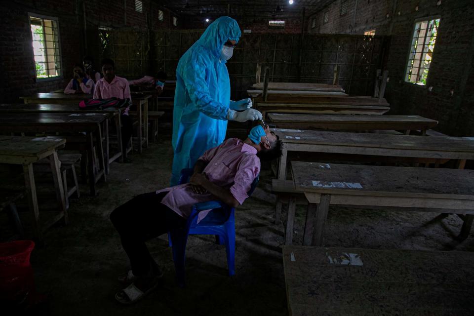 An Indian health worker takes a nasal swab sample of a student to test for coronavirus after classes started at a college in Jhargaon village, outskirts of Gauhati, India, Wednesday, Sept. 30, 2020: AP