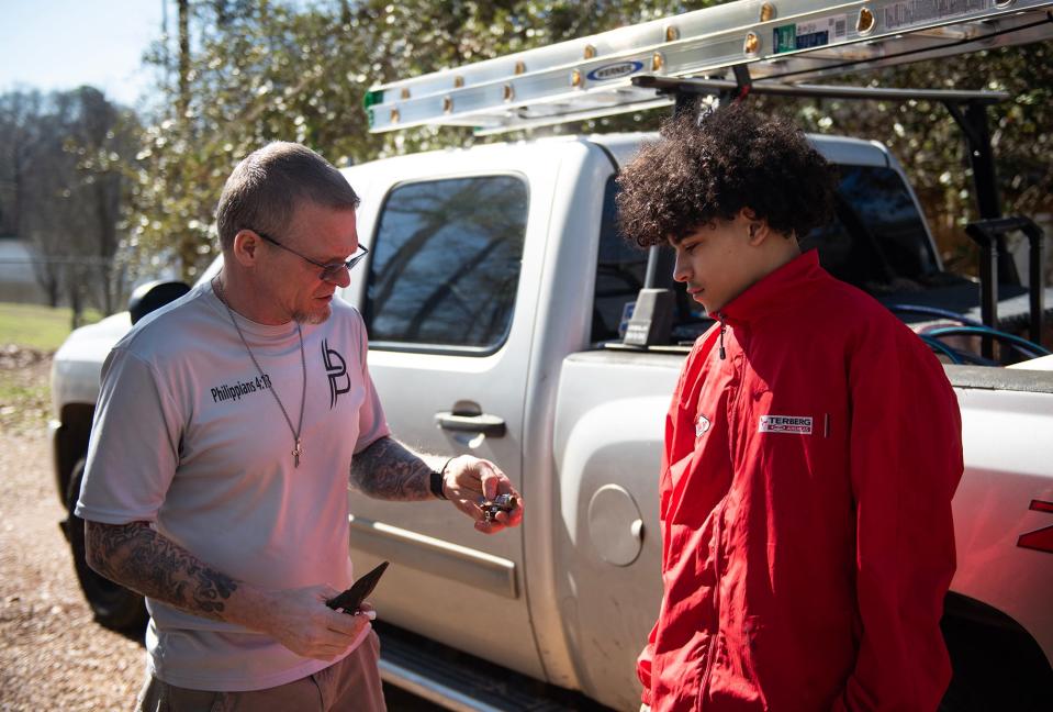 Benny Ivey, 47, gives Trevor Taylor, 15, advice for the water shut-off valve for a toilet at a client's house in Terry, Miss., on Tuesday, Feb. 13. "While I have them on job sites the whole time we're pouring love into them, we're talking to them, we're doing the same things that we would do at our youth group session, which is mentoring," Ivey said. Ivey is now seeking to have his suffrage restored, and he is optimistic about several laws Mississippi House members are working on to do just that.