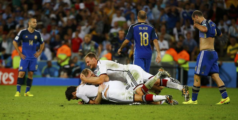 Germany's Benedikt Hoewedes jumps on his teammates after winning the 2014 World Cup final between Germany and Argentina at the Maracana stadium