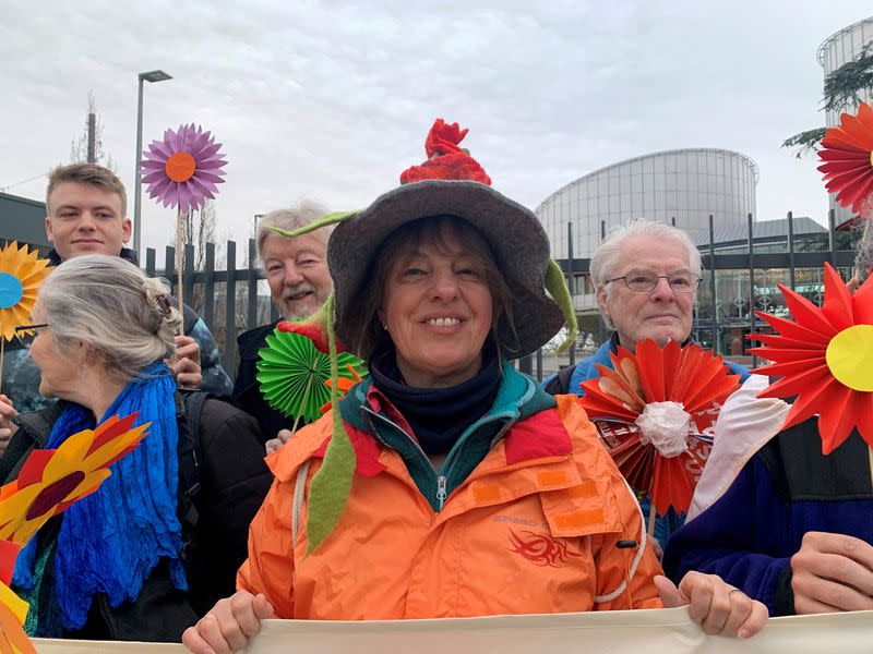 FILE PHOTO: A female supporter smiles while holding a banner in support of the Senior Women for Climate Protection in front of the European Court of Human Rights in Strasbourg