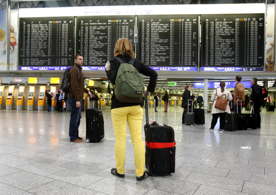 Passengers stand in a terminal at the Frankfurt airport as Lufthansa pilots went on a three-day strike in Frankfurt, Germany, Wednesday, April 2, 2014. Germany's Lufthansa said it has canceled almost 900 domestic and intercontinental flights on the first day of a three-day strike by the pilots' union. Airline spokeswoman Barbara Schaedler said that up to 900 flights were canceled for Wednesday and that it expects to cancel about 3,800 flights altogether, affecting more than 425,000 passengers. (AP Photo/Michael Probst)