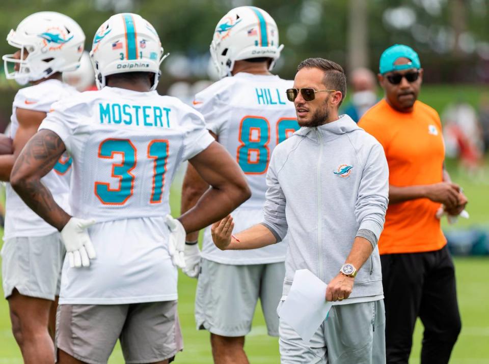 Miami Dolphins head coach Mike McDaniel talks with running back Raheem Mostert (31) during team practice at the Baptist Health Training Complex on Wednesday, May 31, 2023, in Miami Gardens, Fla.