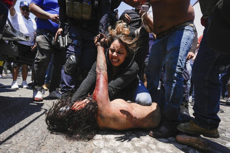 Una turba golpea brutalmente a una mujer, que murió después, al ser señalada como sospechosa del secuestro y asesinato de una niña de 9 años, después de sacarla de un vehículo policial, en Taxco, México, el jueves 28 de marzo de 2024 (AP Foto/Fernando Llano)