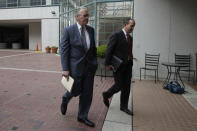 Pacific Gas and Electric Company (PG&E) CEO Bill Johnson, left, walks toward the California Public Utilities Commission headquarters before a meeting in San Francisco, Friday, Oct. 18, 2019. (AP Photo/Jeff Chiu)