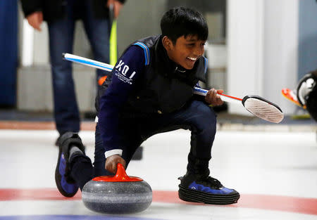 A refugee from Sri Lanka, Arun Daniel, learns the sport of curling at the Royal Canadian Curling Club during an event put on by the "Together Project", in Toronto, March 15, 2017. REUTERS/Mark Blinch