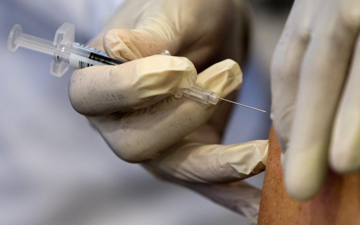 A nurse administers a flu vaccine  - AP