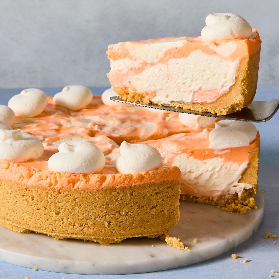 no bake creamsicle cheesecake with dollops of whipped cream and a graham cracker crust