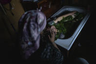 Millaray Huichalaf, a Mapuche machi, or healer and spiritual guide, bathes a woman suffering from pneumonia with native plants as part of a medicinal practice known as lawen at her home in Carimallin, southern Chile, on Sunday, June 26, 2022. Huichalaf became seriously ill as a child in the nearby city of Osorno until her family realized it was an ancestor's spirit wanting to come back in her as a healer. (AP Photo/Rodrigo Abd)